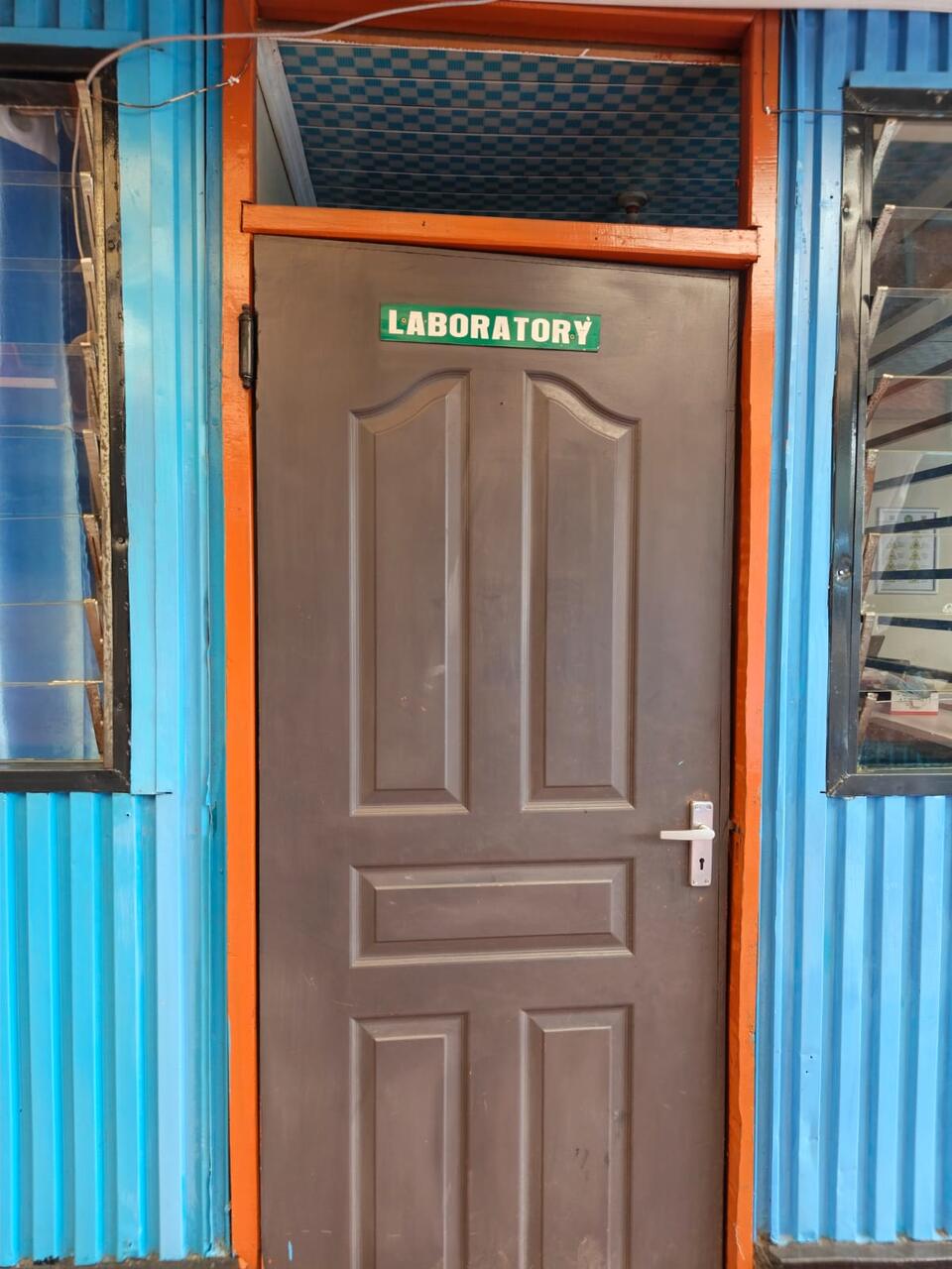 The laboratory door at Primegala, marked with a green 'Laboratory' sign
